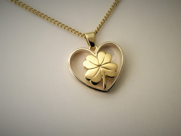 Bicolor trouwring met gouden klavertje. Hartvorm met kamertje voor as van overledene. Dierbare herinnering Goudsmid Hans Rietman